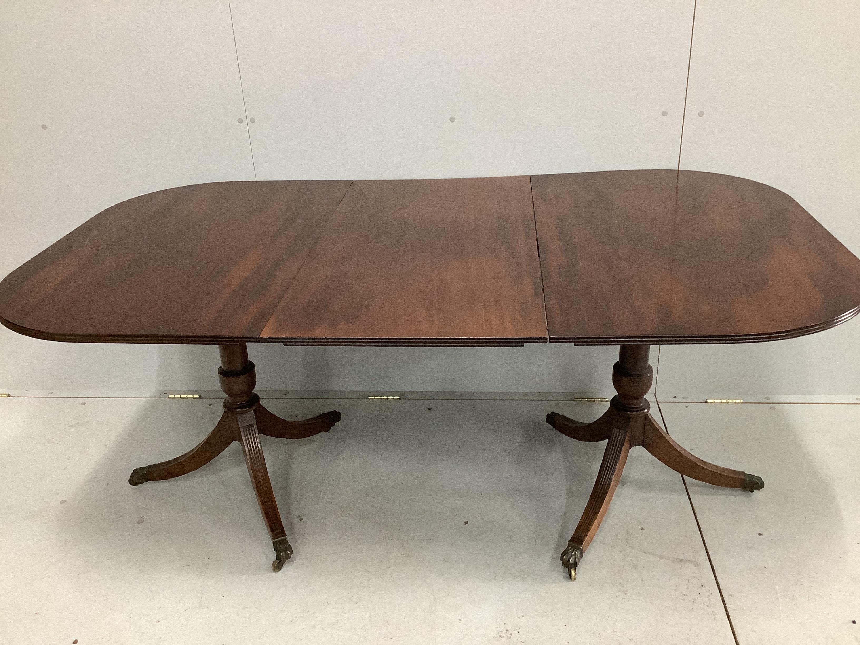 A George III and later mahogany twin pillar extending dining table, 176cm extended, one spare leaf, depth 98cm, height 75cm